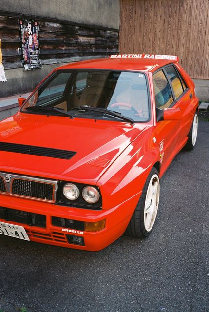 A red rally car parked on wet tarmac