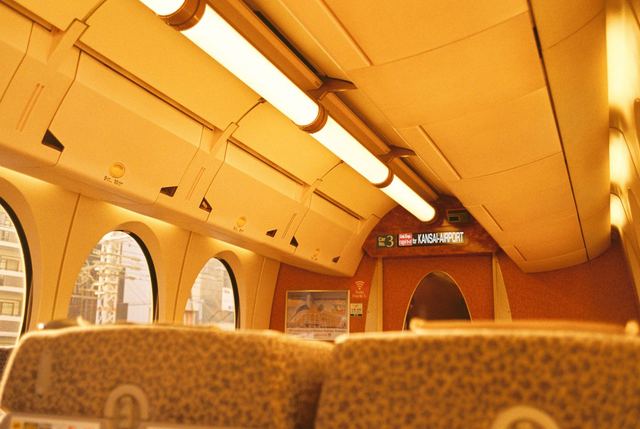 Inside a train carriage in amber light, round windows